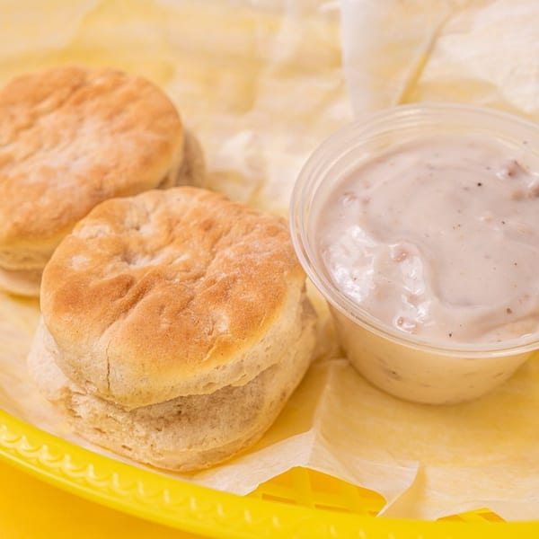 Stack House southern biscuits and gravy, with two golden-brown biscuits and a side of creamy sausage gravy.