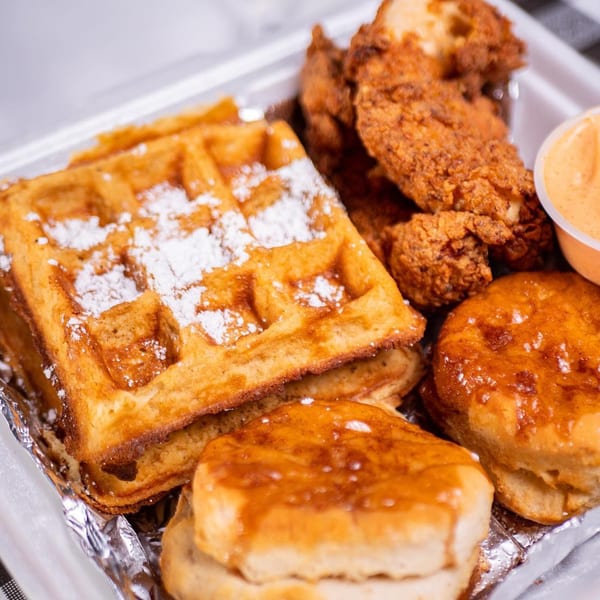 Stack House southern fried chicken, waffles with powdered sugar, and biscuits with honey glaze.