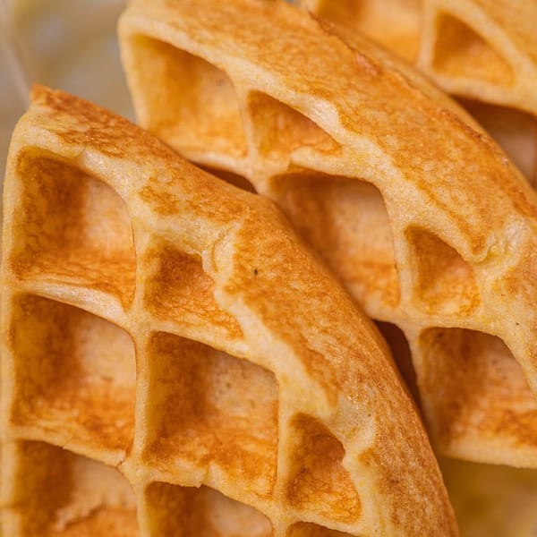 Close-up of golden-brown Stack House waffles with deep pockets, ready for syrup.