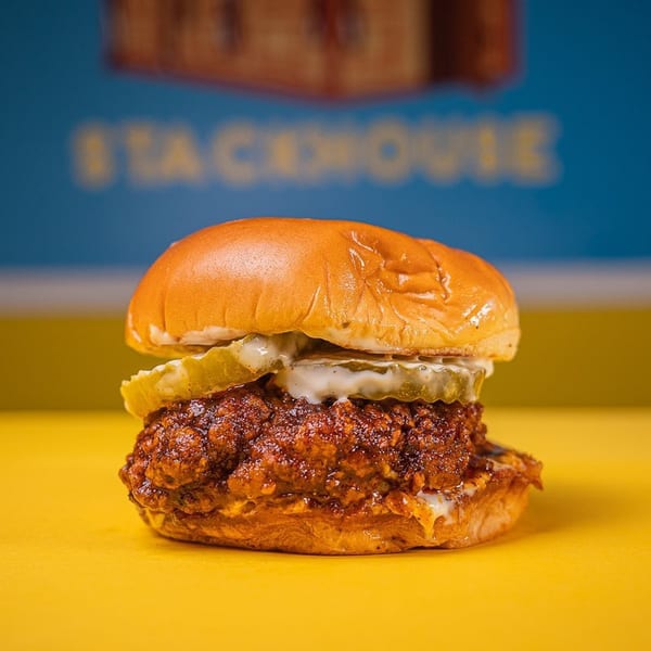Stack House's southern fried chicken sandwich with pickles and sauce on a brioche bun.